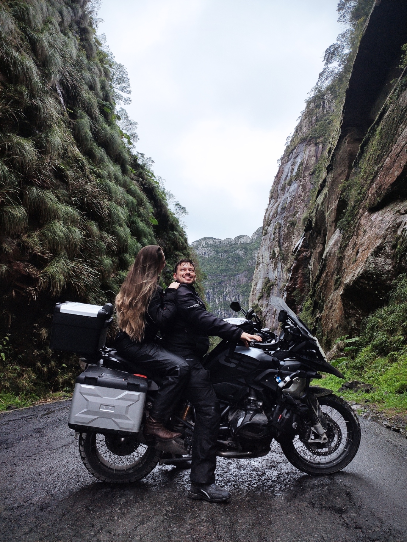 Gabriela e Marcelo de moto entre paredões de rocha na Serra do Rio do Rastro