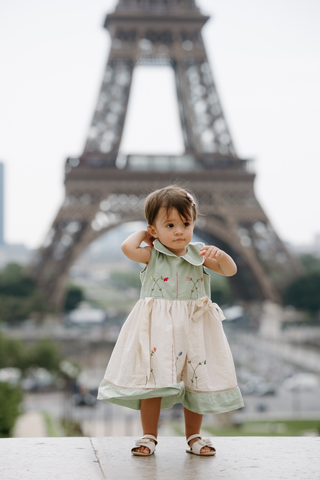 Sofia em um vestidinho verde em frente à Torre Eiffel